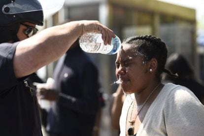 Un policía lava la cara de una mujer que fue alcanzada por spray de pimienta, ayer en Baltimore.