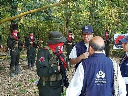 Funcionarios de la  Defensoría del Pueblo hablan con guerrilleros del ELN, durante la liberación de varios soldados y un policía en zona rural de Arauca, el 17 de agosto de 2022.