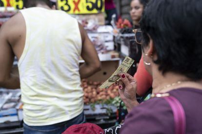 Una clienta espera a un vendedor en un puesto de frutas en Ciudad de México, el 9 de mayo de 2023.