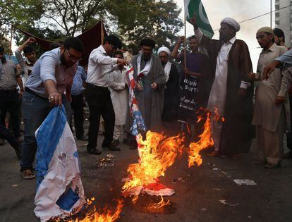 Decenas de personas queman banderas estadounidenses e israelíes durante una protesta en Karachi (Pakistán) hoy, 15 de mayo del 2018. 