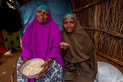 Dos mujeres enseñan la mercancía que venden en el mercado de Dadaab. Los vecinos aseguran que la distribución es menor. "Antes daban trigo, ahora solo maíz, y menos cantidad", dice un padre.