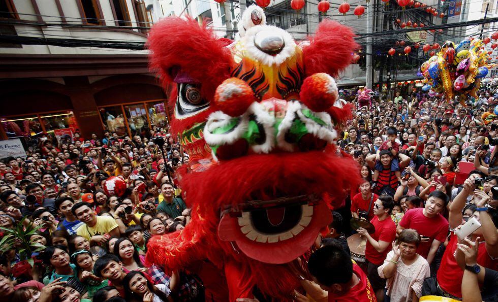 La multitud rodea a los bailarines de la danza del León en el barrio chino de Manila, Filipinas, durante la celebración del inicio del Año Nuevo chino.