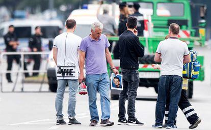 El padre de una víctima sujeta un retrato de su hijo cerca del centro comercial Olympia, Múnich (Alemania), el 23 de julio de 2016.