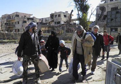 Un grupo de civiles traslada sus pertenencias hasta el punto de encuentro se&ntilde;alado en Homs para la evacuaci&oacute;n. 