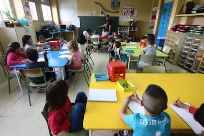 Un maestro da clase a alumnos en un aula del colegio público Manuel Núñez de Arenas, en el Pozo del Tío Raimundo.