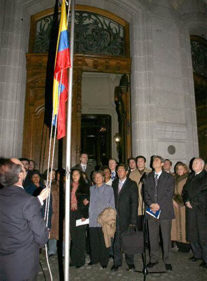 Familiares de los ecuatorianos Palate y Estacio observan el izado de la bandera de su país en la Casa de América de Madrid.