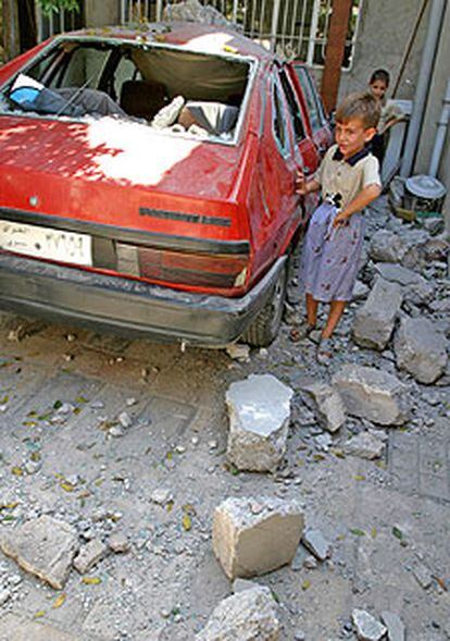 Un niño, delante de su casa tras un ataque con morteros ayer en Mosul.