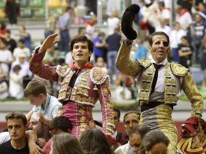 Los diestros Jos&eacute; Garrido (izquierda) y Juan Jos&eacute; Padilla salen ayer martes a hombros tras el cuarto festejo taurino de la feria de San Pedro y San Pablo de Burgos.