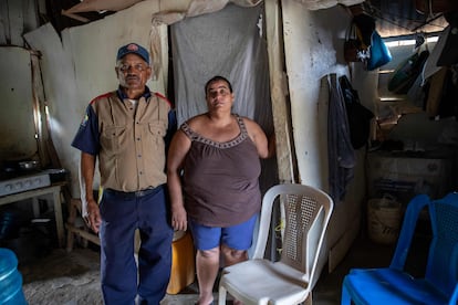En las paredes rosadas de la vivienda de Quisqueya Estevez está la marca "MF 032". La casa sigue a la espera de ser demolida, aunque la sección en la que estaba el baño cedió por un deslizamiento de tierra por las obras. Estevez niega haber sido indemnizada por las autoridades. En la imagen, Quisqueya Estevez y Antonio Ramírez posan para un retrato, al interior de su vivienda en Dajabón. 