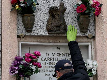 Un hombre visita el nicho de su madre en un cementerio de Madrid.