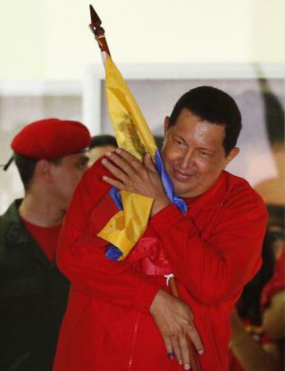Ch&aacute;vez abraza la bandera venezolana.