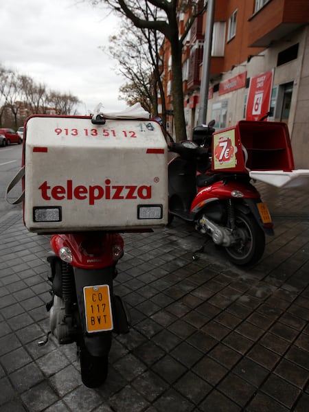 Motos de reparto apostadas frente a un local de Telepizza.