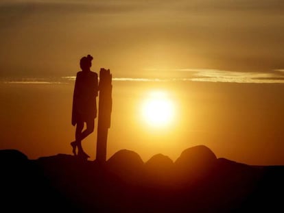 Una mujer disfruta de la llegada del verano con la puesta de sol