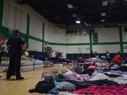 Miembros de la Policía observan a personas en uno de los refugios anti huracán de Miami.