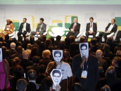 Asistentes a la cumbre de Internet de Sao Paulo muestran fotos de Edward Snowden durante la intervenci&oacute;n de Dilma Rousseff.