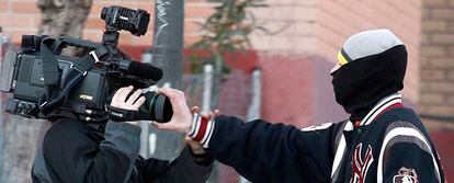 Uno de los jóvenes encapuchados tapa el objetivo de la cámara de uno de los reporteros presentes en los incidentes de hoy en Alcorcón.