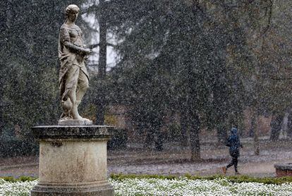 Un hombre hace footing bajo la nieve en el Parque del Retiro de Madrid.