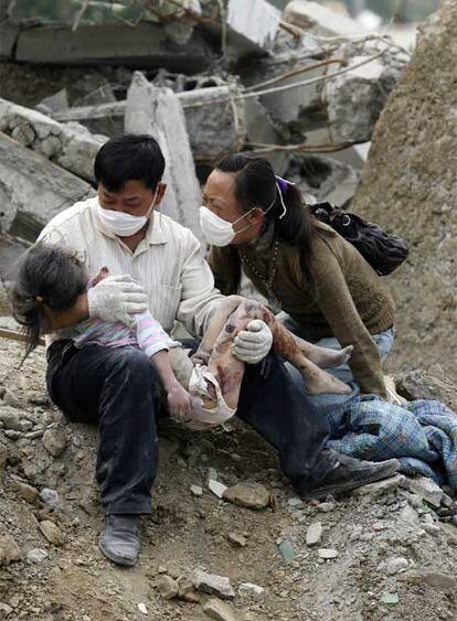 Una pareja llora la muerte de su hija tras haber rescatado su cuerpo entre los escombros, en Beichuan.