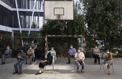 Un grupo de vecinos espera su turno de vacunación en el colegio público Carmela Carvajal, en Santiago de Chile.