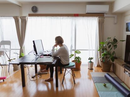 Una mujer teletrabaja desde el salón de su casa.