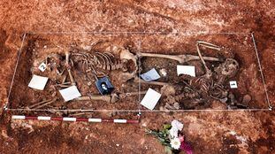 Imagen de dos de los cadáveres encontrados junto a objetos depositados por los familiares.