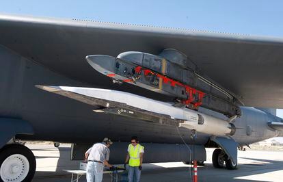 Operarios trabajan debajo del ala del avión no tripulado X-51A Waverider