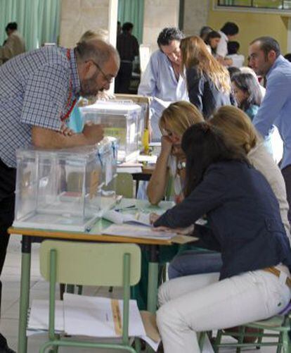 Los miembros de una mesa electoral comprueban el censo durante la apertura de las urnas en un colegio de Aravaca (Madrid).