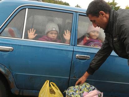 Unos niños miran por la ventana de un coche a su llegada a un campo de refugiados ucranios procedentes de la región de Járkov en la ciudad rusa de Bélgorod, el miércoles.