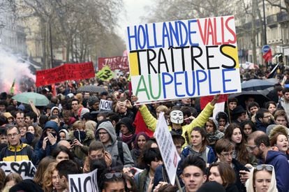 El manifestante Jean-Baptiste Redde aka Voltuan,sostiene un cartel que dice "Hollande, Valls, traidores a la gente", en referencia al presidente francés, François Hollande, y el primer ministro, Manuel Valls, en París.