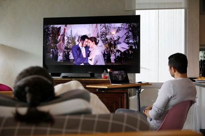 Paola y Nicolás Suárez observan el video de su boda. 