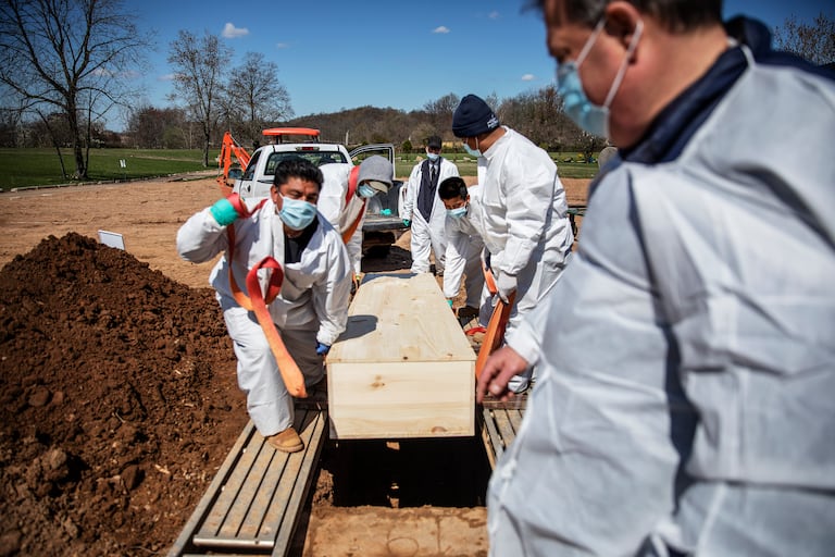 Trabajadores funerarios llevan un cuerpo de una víctima por covid en Staten Island, Nueva York, en una imagen del 6 de abril.