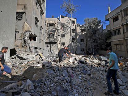 Habitantes de la Franja de Gaza buscan pertenencias entre los escombros de un edificio tras los ataques aéreos israelíes.