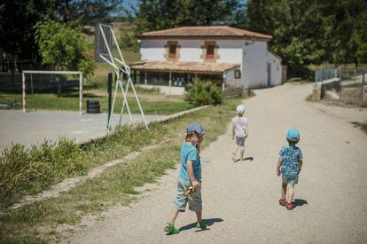 Varios niños pasean por la calle hacia la escuela de Fuentelfresno.