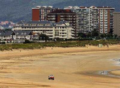 Un todoterreno de la policía patrulla la playa de Laredo tras hacer explosión dos de las bombas.