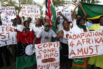 Varias personas protestan en la sede donde se celebra la cumbre de Durban (Sudáfrica) para reclamar "justicia climática".