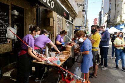 Un puesto al aire libre sirve raciones de pulpo durante la celebración de la Fiesta del Pulpo, el 8 de de agosto de 2021, en O Carballiño, Ourense (Galicia).