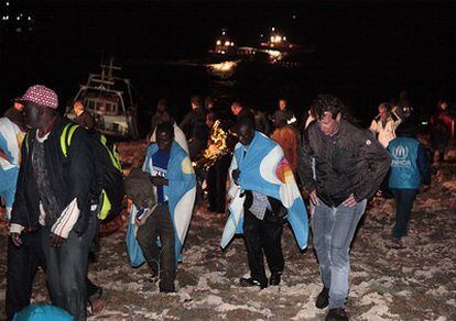 Inmigrantes subsaharianos procedentes de Libia llegan a la isla italiana de Lampedusa, tras ser rescatados del agua al encallar su barco cerca del puerto.