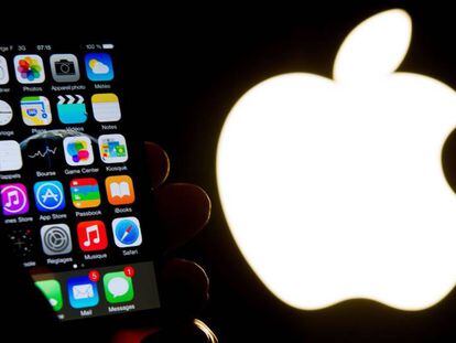 Un iPhone junto al logo de Apple. 