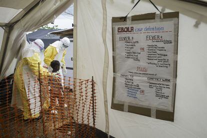 Un equipo de doctores muestra el camino hacia el centro de aislamiento a una joven paciente que ha contraído el Ébola.