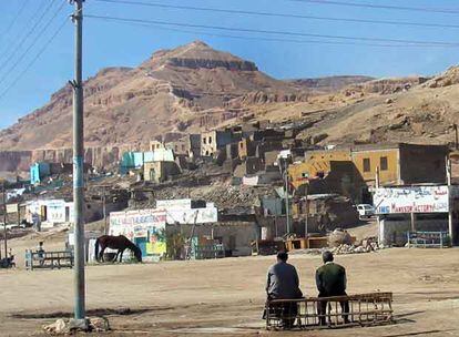 Imagen de Qurna. Delante, los edificios en curso de demolición. Detrás, la montaña piramidal llamada El Qurn, sagrada para los antiguos egipcios.