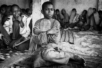 Los niños que acuden a las 'daaras' (escuelas coránicas no tendrían que mendigar para sobrevivir, pero en la práctica hay much)os niños por las calles de Senegal que piden unas monedas con la mano en alto mientras recitan el Corán. En 2010, Human Rigths Watch publicó un informe en el que apuntaba que al menos 50.000 niños viven internados en escuelas coránicas en Senegal sometidos a condiciones de vida parecidas a las de la esclavitud. En la imagen, un niño talibés abraza una de las tablas con el texto sagrado musulmán.