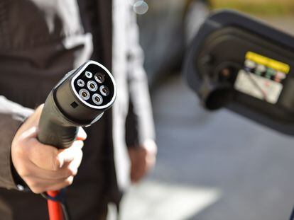 Un conductor recarga su coche eléctrico.