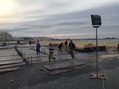 Obreros de la construcción trabajan al anochecer en Tánger en las obras del paseo marítimo, el pasado 17 de abril.