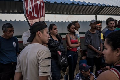 Migrantes centroamericanos esperan en una fila de salida en la aduana de Suchiate, Chiapas.