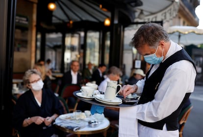 Un camarero, en la terraza de un café parisino.