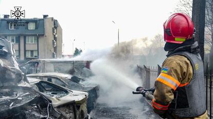 Un bombero apaga las llamas de un vehículo alcanzado por fragmentos de un misil, este jueves en Kiev.
