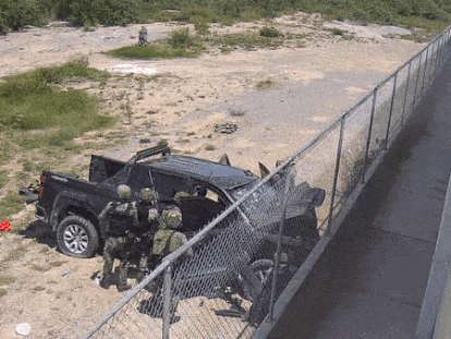 Soldados inspeccionan la camioneta, mientras un sujeto, vendado y atado, rueda al fondo, el 18 de mayo en Nuevo Laredo (Tamaulipas).