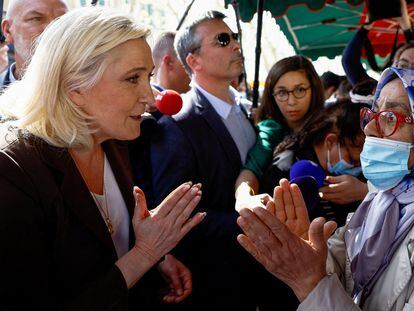 Marine Le Pen discute con una mujer que lleva el pañuelo islámico durante una visita de la campaña a Pertuis, cerca de Marsella, el 15 de abril.