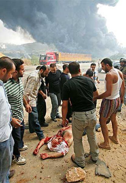 Un grupo de libaneses rodea el cuerpo de un hombre muerto cerca de Beirut por las esquirlas de un obús israelí.
