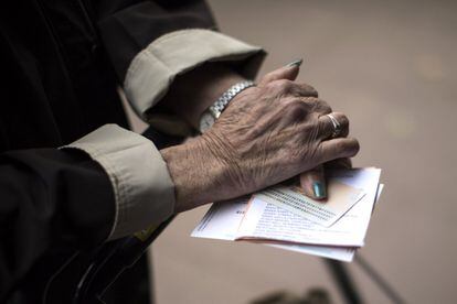 Una mujer sostiene sus papeletas junto con su documentación, antes de votar en un centro electoral de Barcelona.